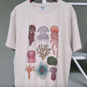 The Jellyfish T-Shirt showcases a mesmerizing design of these graceful ocean creatures. Made with high-quality fabric, it's comfortable and durable. Ideal for marine enthusiasts and anyone looking to make a statement. Perfect for animal lovers and those who appreciate unique t-shirt designs.